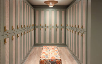 Interior view of a minimalist locker room with green cabinets and a floral bench.